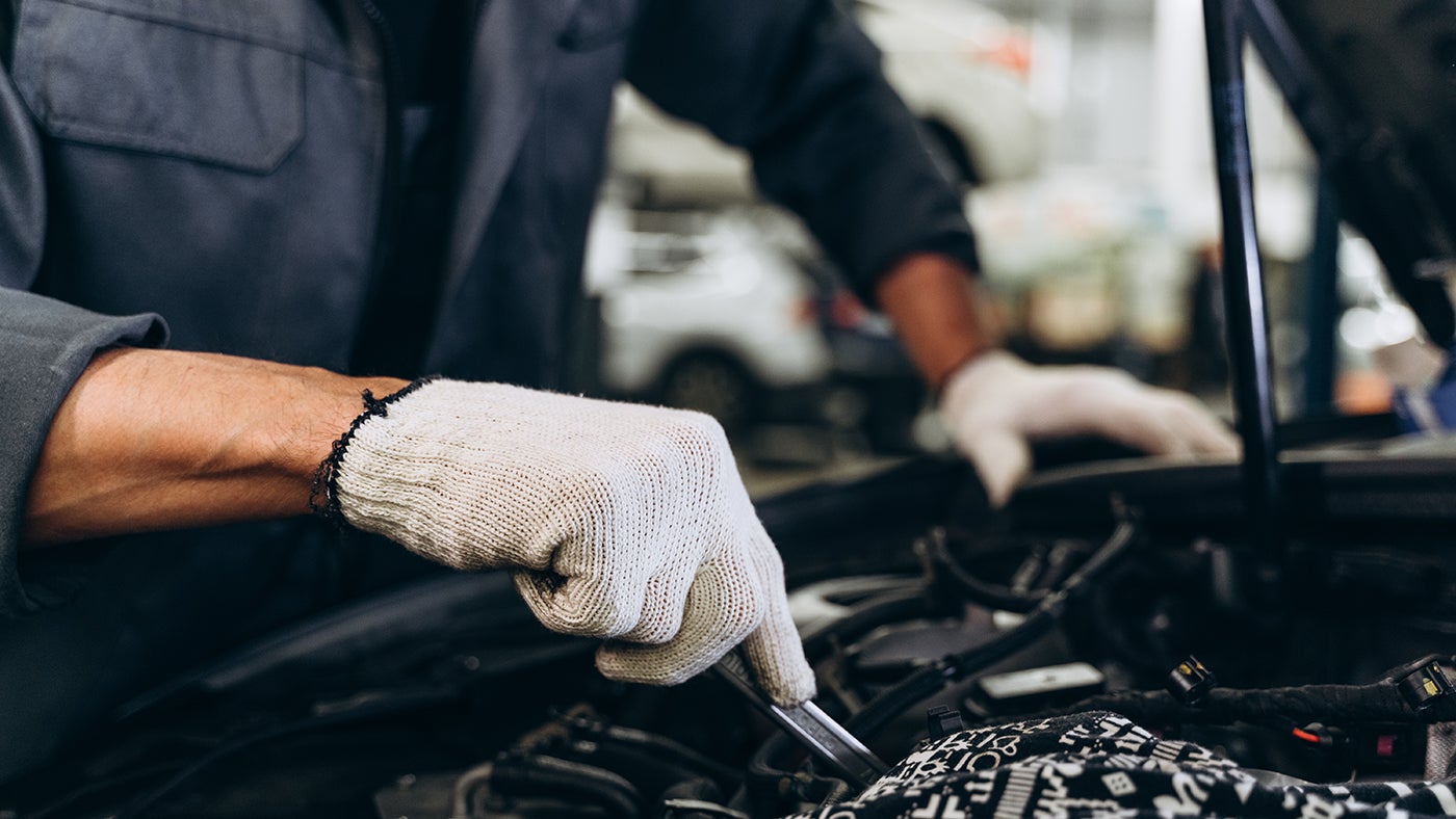 Mechanic Repairs Car in Garage